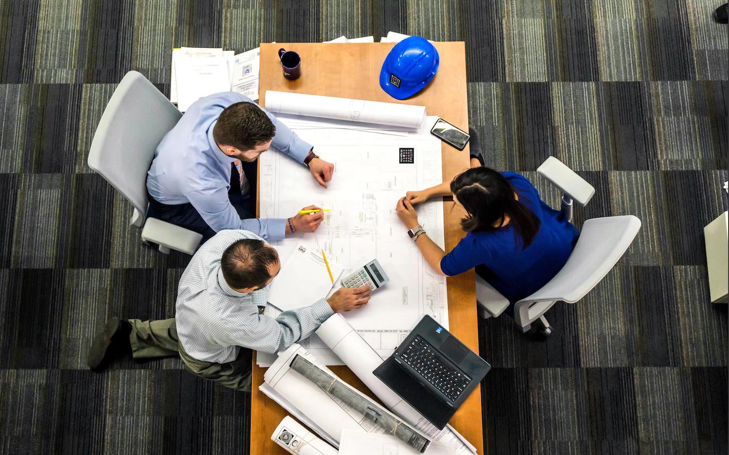Experts de Millius Groupe analysant des plans techniques pour la gestion et la rénovation après un sinistre en Valais
