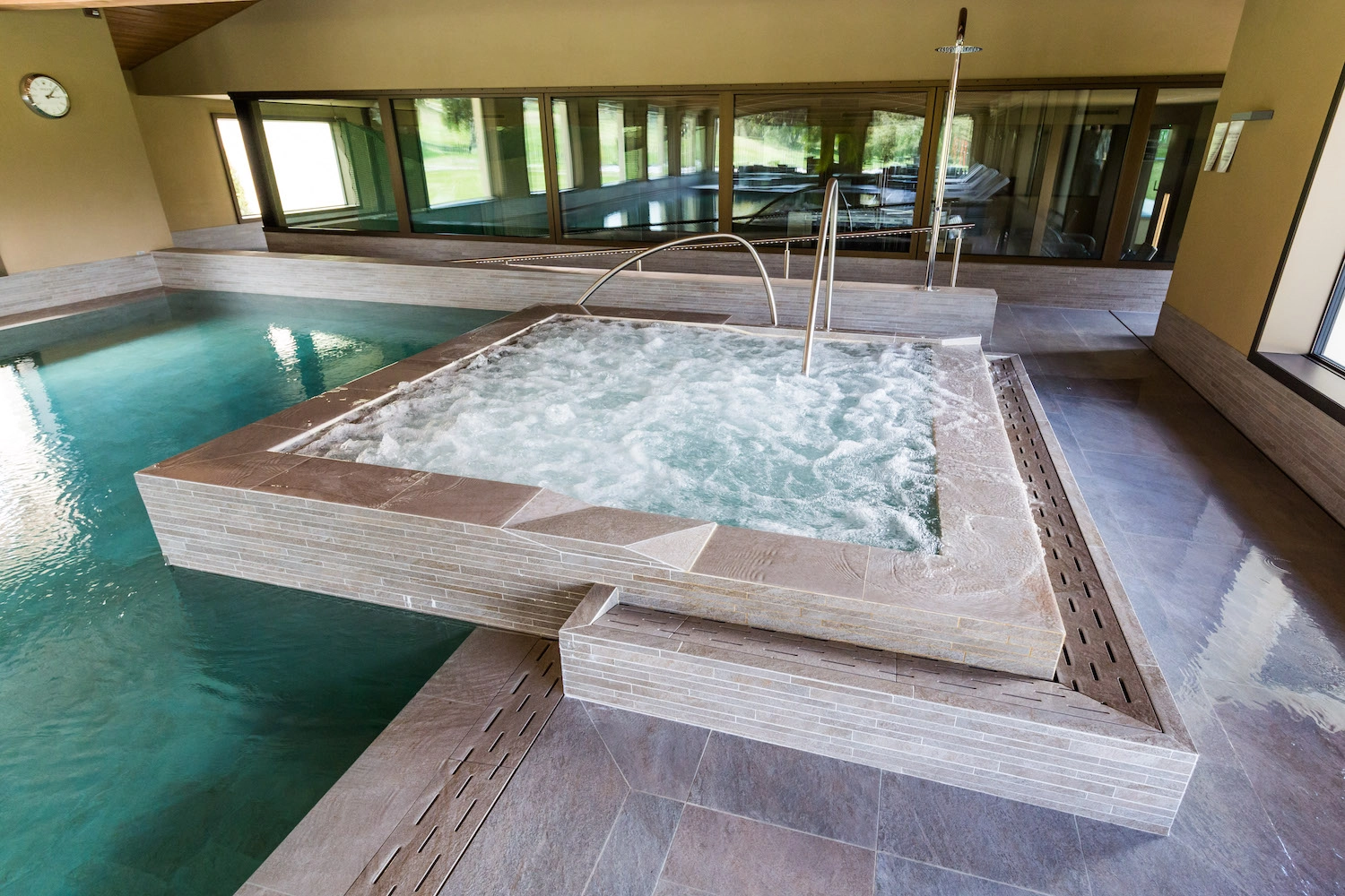 Application du système d'imperméabilisation sous le carrelage d'une piscine intérieure haut de gamme en Valais