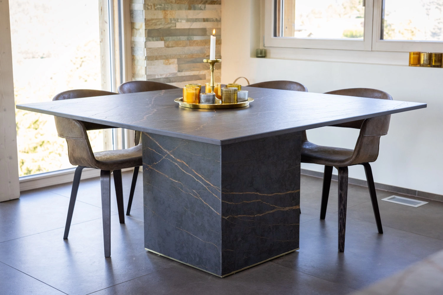 Table en marbre foncé façonnée sur mesure dans le salon d'un chalet moderne en Valais par Millius Atelier