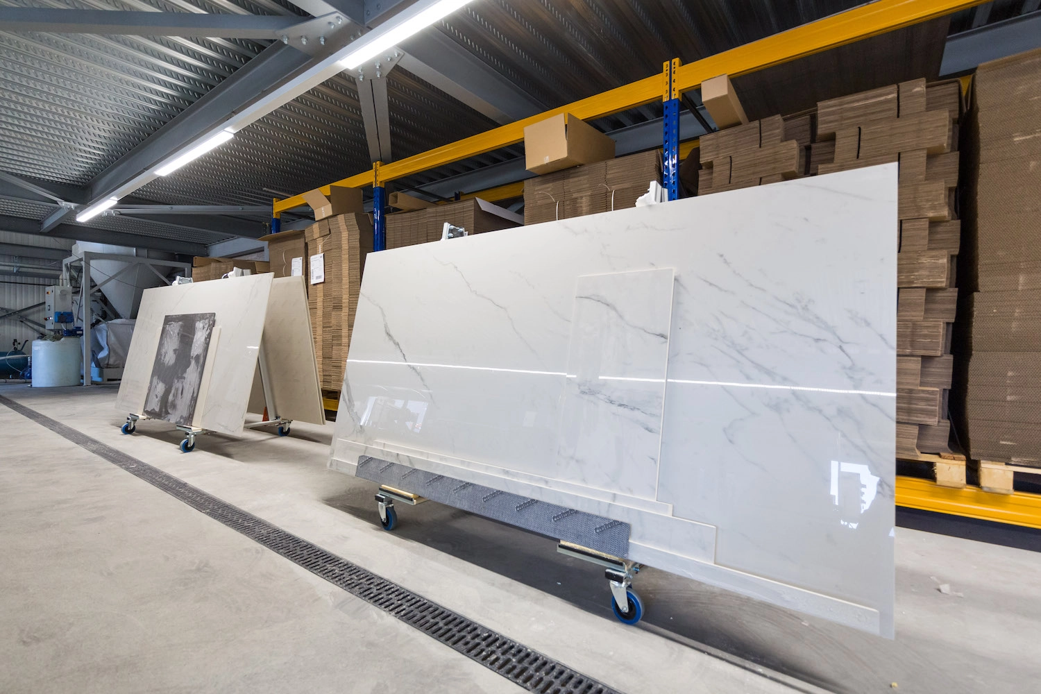 Stock de tranches de marbre blanc géantes dans la halle de stockage et de façonnage de Millius Atelier en Valais